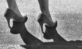 Someone in heels on a sidewalk.