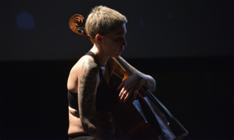 close up of an actor playing the cello