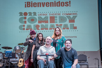 Five people posing for a photo with the Comedy Carnaval banner behind them.
