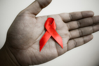Photo of a red ribbon on a hand.