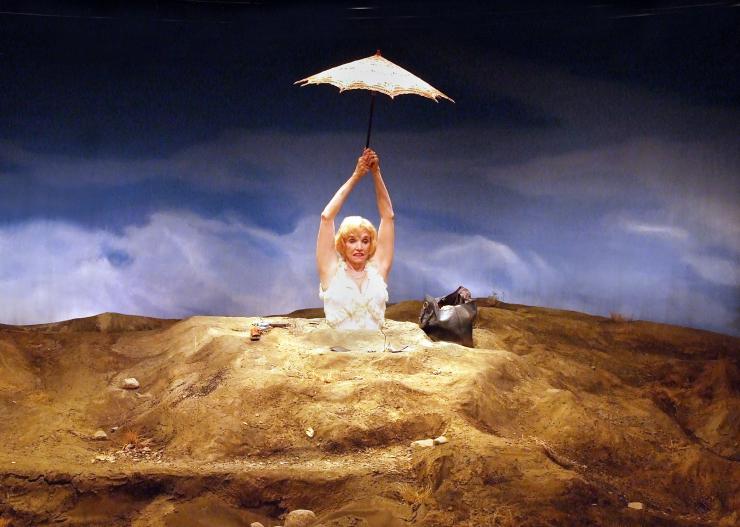 An actor on stage with an umbrella 