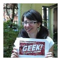 Crystal Skillman smiling at the camera and holding a poster for Geek!.