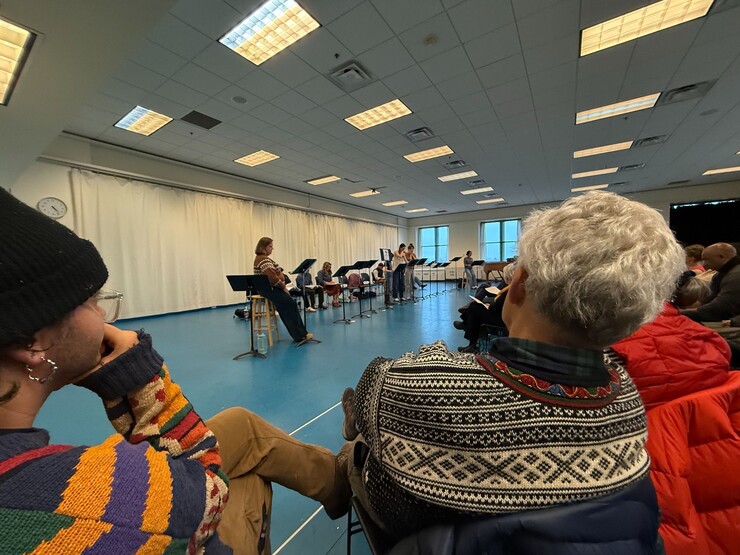 A group of people watch a staged reading.