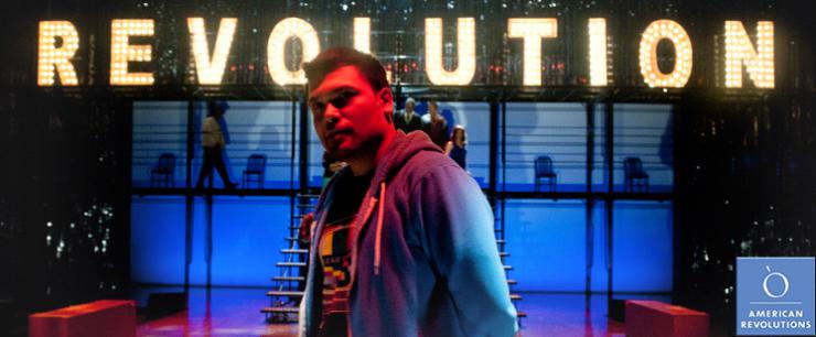 an actor on stage under multicolored lights. 