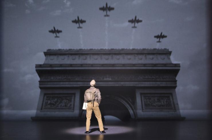 Actor looking at an Arc de Triomphe setpiece