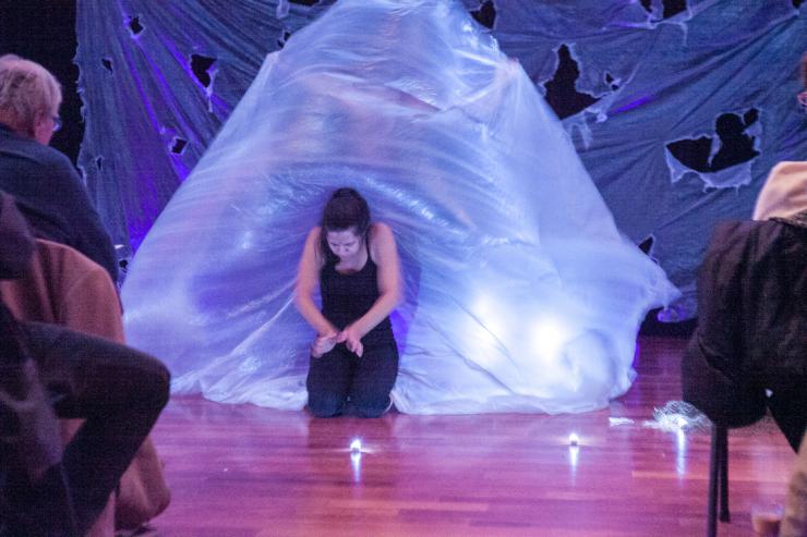 an actress performing in front of a white flowing tarp