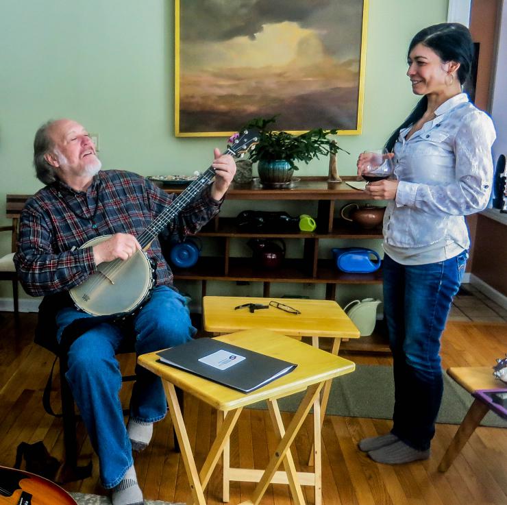 a man playing a guitar and a woman listening
