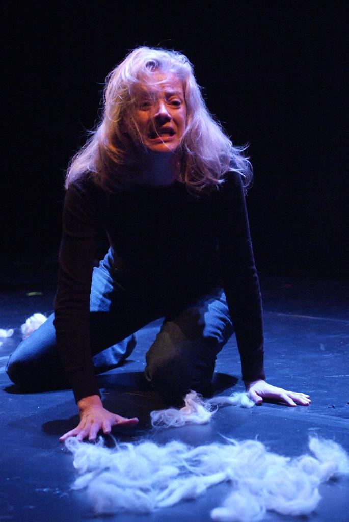An actor crouching onstage. 