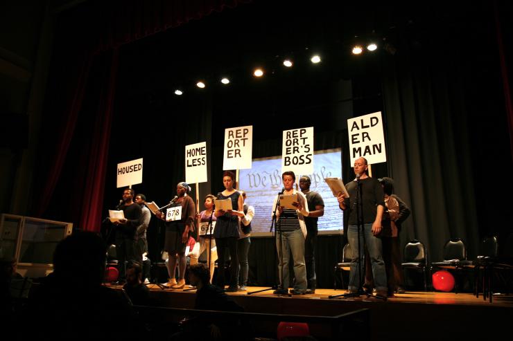 a group of performers reading on stage 