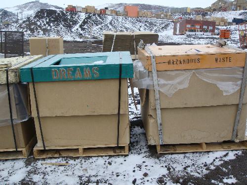 Large wooden crates in a row. One is labelled DREAMS in large painted letters.