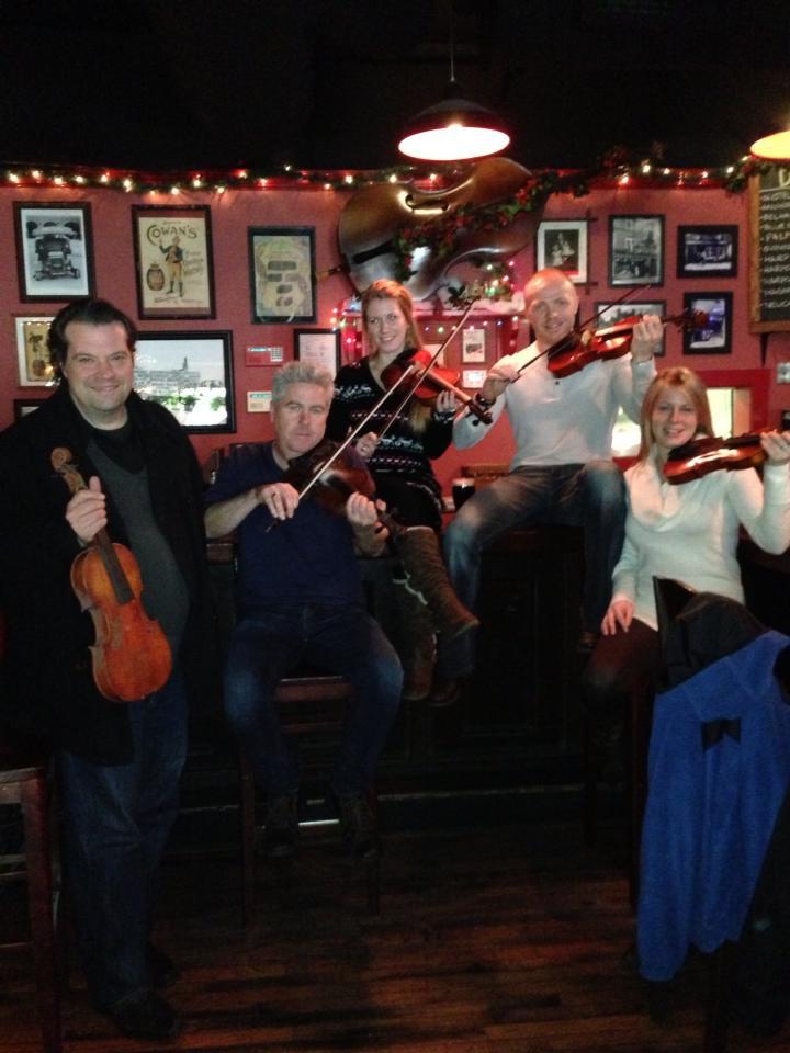 a group of people posing with violins