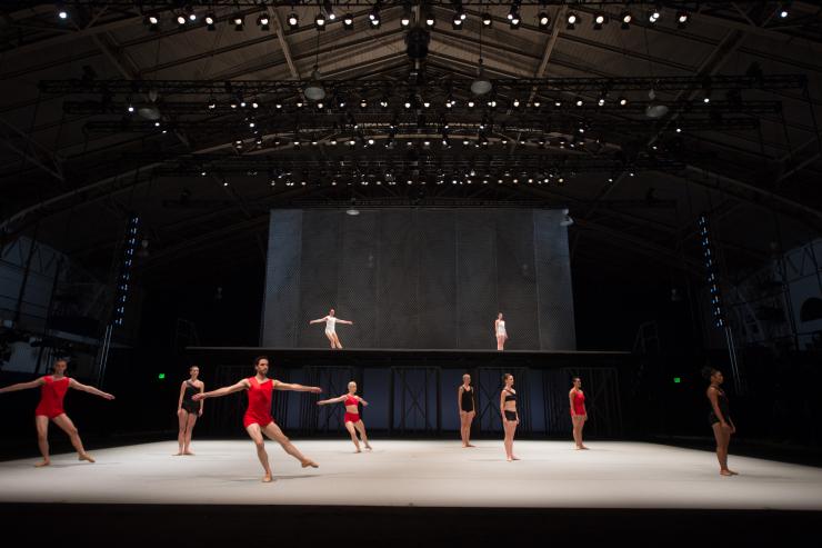 Ballet performers in red and black on stage