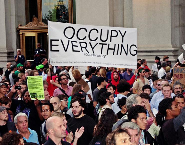 Protesters with sign saying "Occupy Everything".