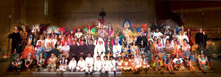 The full cast of La Virgen de Guadalupe poses onstage in costume for a cast photo.