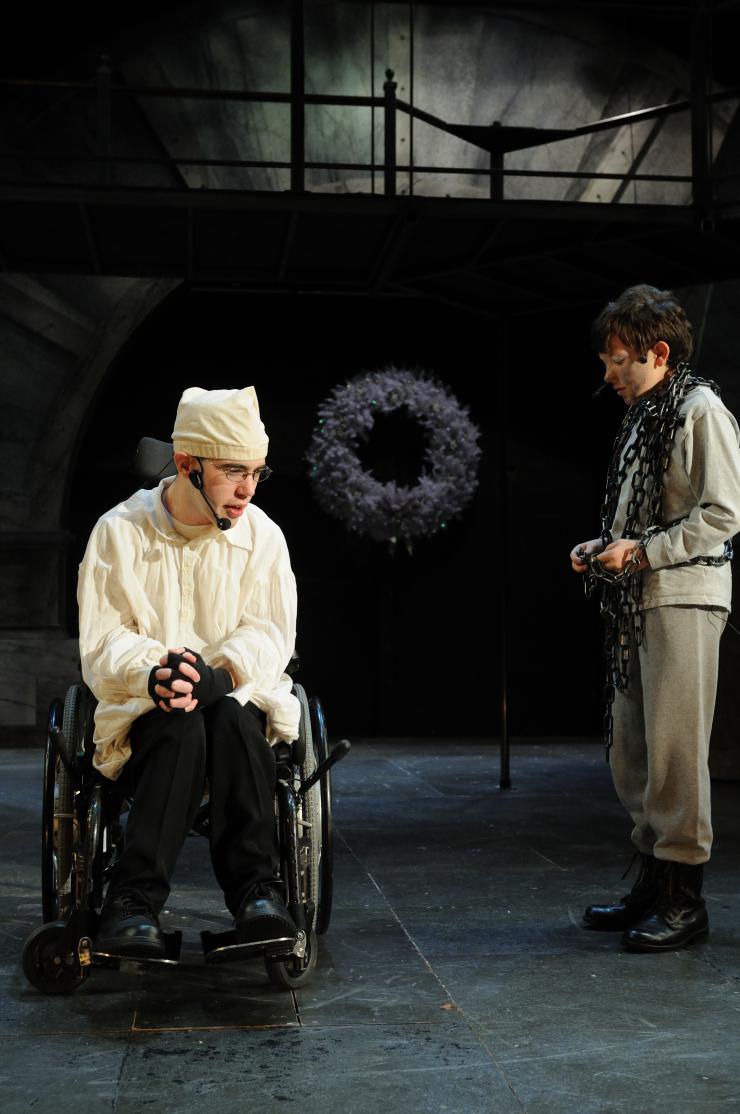 Two performer onstage, one in a wheelchair