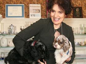 Portrait of Karen Malpede posing with two dogs.