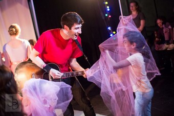 An adult and a child playing onstage. 