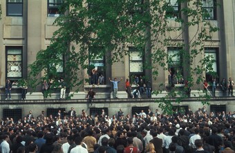 students crowding and surrounding the exterior of an university building