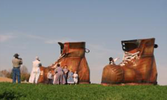Two giant shoes with people gathered around.