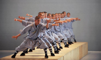 Actors performing martial arts in a line.