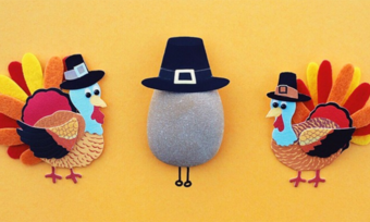 Two turkeys and a rock wearing pilgrim hats.