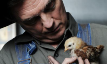 A man with a baby chick.