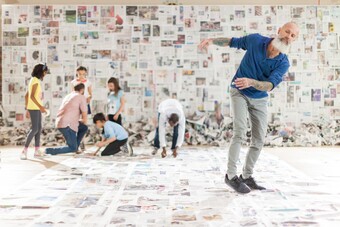 actors in front of a colorful wall of newspaper