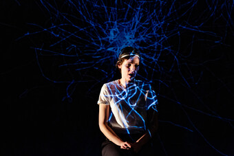performer with a projection of a neural net displayed on and above them.