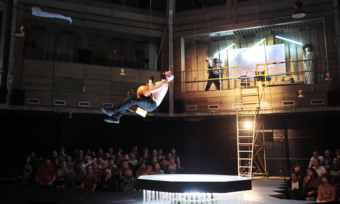 an actor swinging above stage