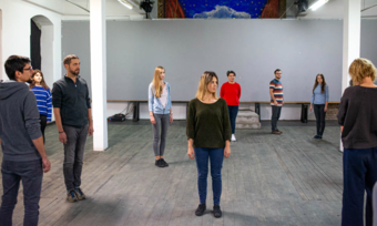 nine people standing in a large space