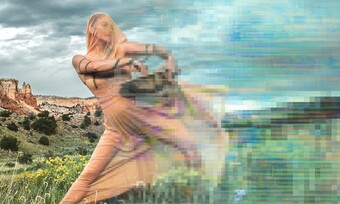 A person standing on a hill, partly pixelated and blurred.