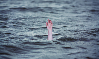 a lightskinned hand reaching up out of water