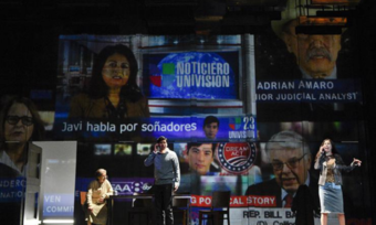 Three performers onstage with Spanish-language projections behind them