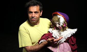 performer in yellow shirt with a puppet.