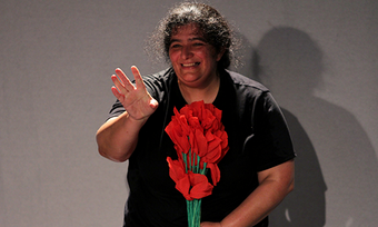 Performer with a bouquet of red paper flowers. 