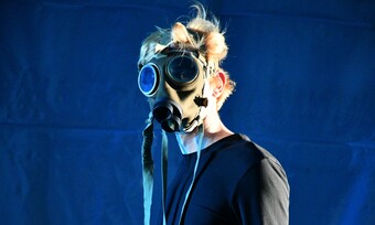 An actor wearing a gas mask covering their entire face.