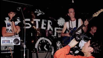 A candid color photograph of a band performing on stage.