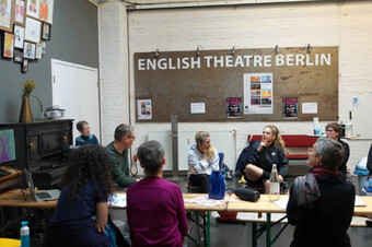 Artists workshop at a table in a classroom.