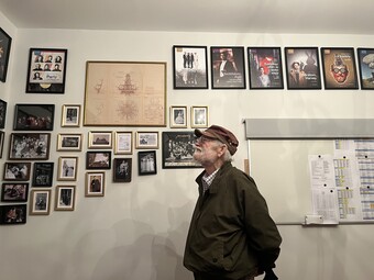 Philip stands in front of a wall of frames