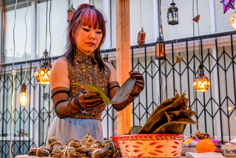 A woman making food with leaves.