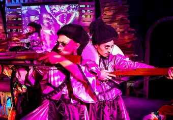 Actors in bright costumes pose onstage.