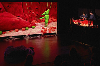 A stage screen that projects a small puppetry scene.