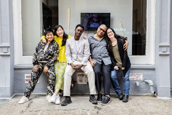 A group of people sitting together outside a city building. 