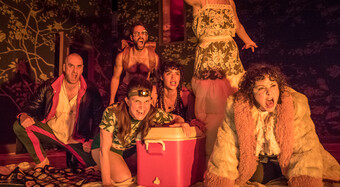 A group of people acting menacing in fire light.