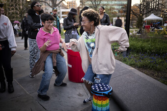 A few people in colorful clothing dancing outside.
