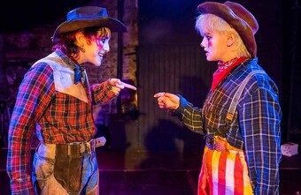 Two people in clown costumes looking at each other.