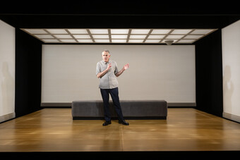A man in the center of an empty room.