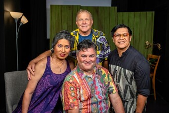 Four people in tropical clothes smiling.