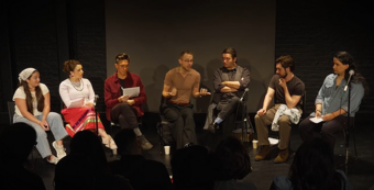 A group of people sitting in a row in chairs.