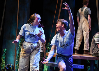 Two performers make faces onstage. 